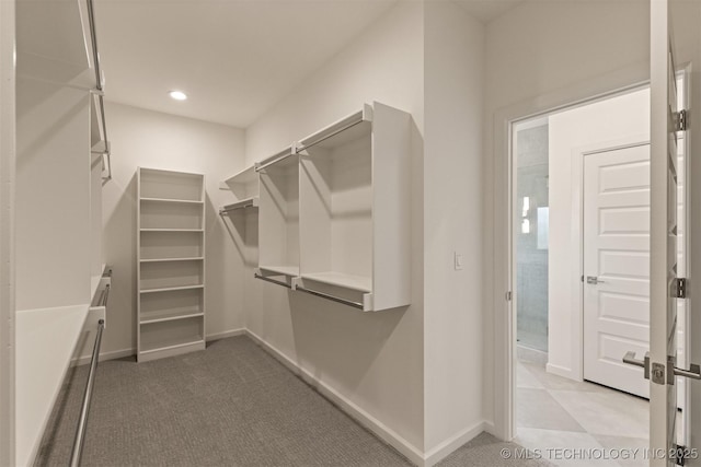 walk in closet featuring light colored carpet