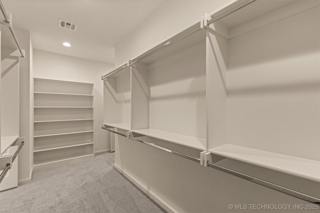 walk in closet featuring visible vents and light colored carpet