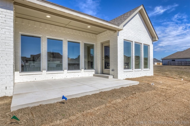 rear view of property with a patio area and brick siding