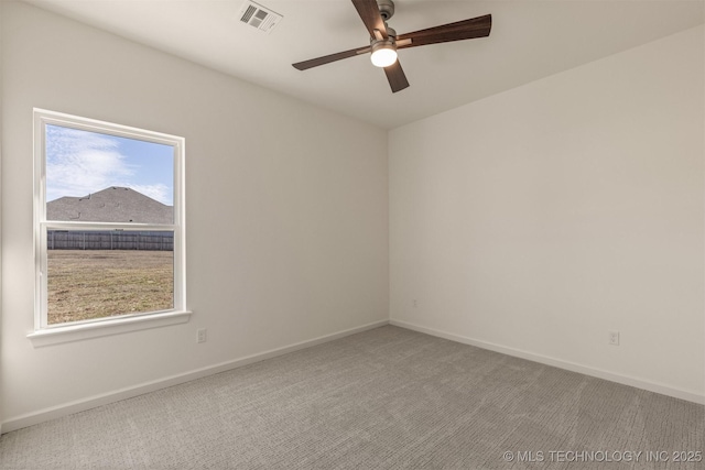 spare room featuring baseboards, visible vents, ceiling fan, and carpet flooring