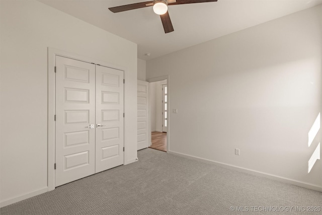 unfurnished bedroom featuring carpet, a closet, ceiling fan, and baseboards