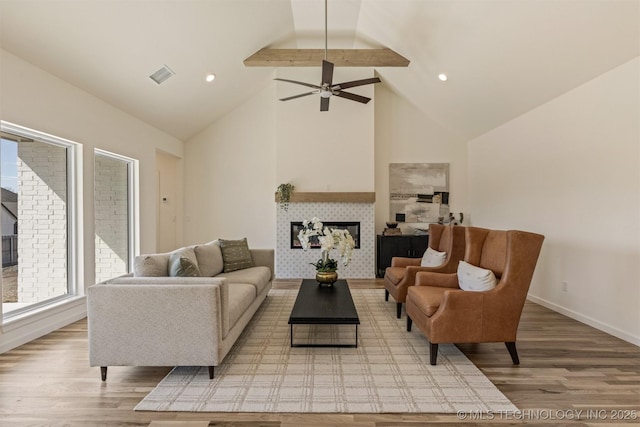 living room featuring a fireplace, wood finished floors, visible vents, and baseboards