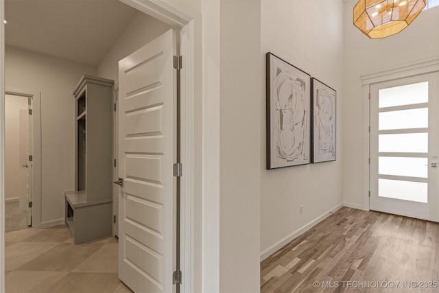 hallway featuring light wood-type flooring and baseboards