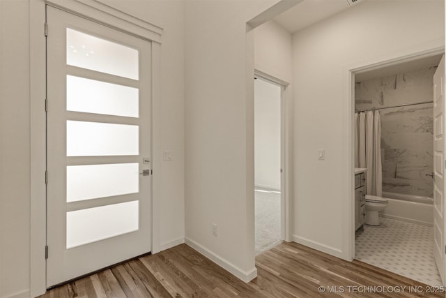 foyer entrance with light wood-type flooring and baseboards