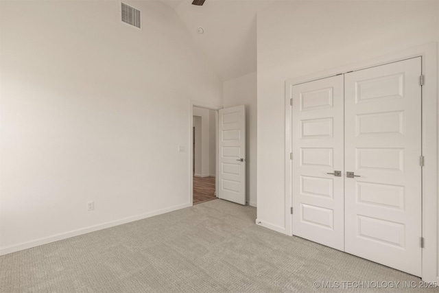 unfurnished bedroom with light carpet, a closet, visible vents, and baseboards