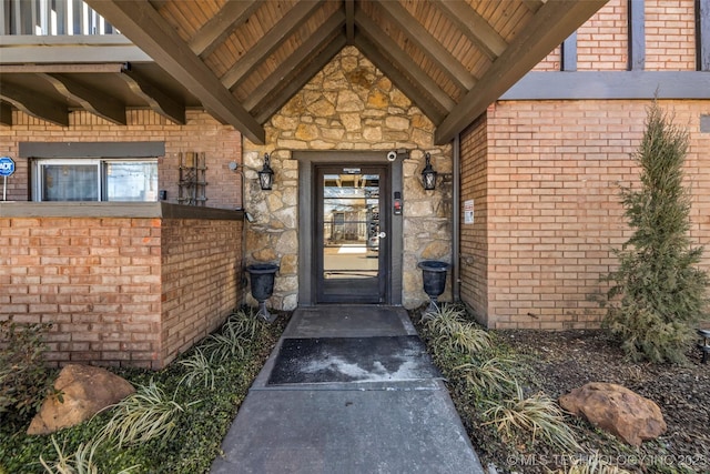 property entrance with stone siding and brick siding