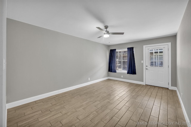 empty room with ceiling fan, baseboards, and wood finished floors