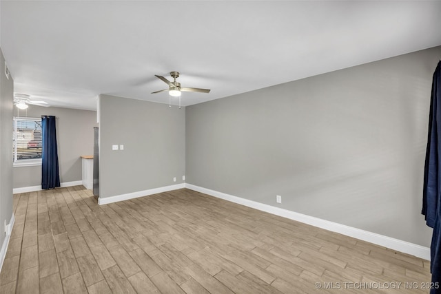 unfurnished room featuring baseboards, a ceiling fan, and wood finished floors