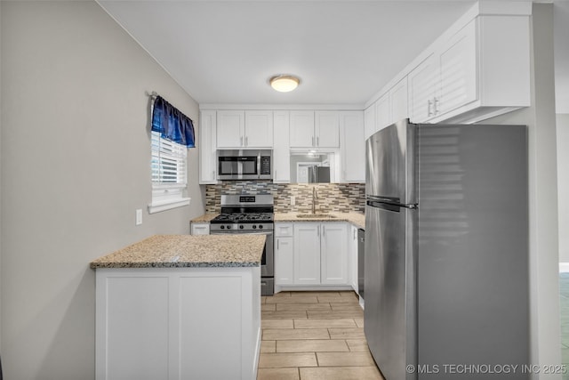 kitchen with white cabinetry, appliances with stainless steel finishes, tasteful backsplash, and a sink