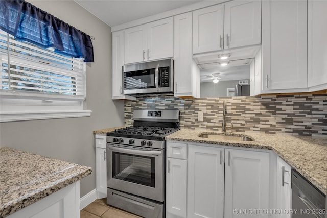 kitchen featuring white cabinetry, appliances with stainless steel finishes, backsplash, and a sink