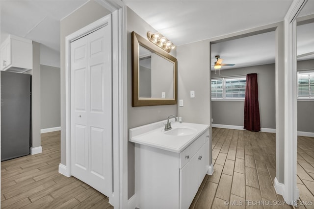 bathroom with ceiling fan, baseboards, vanity, and wood tiled floor