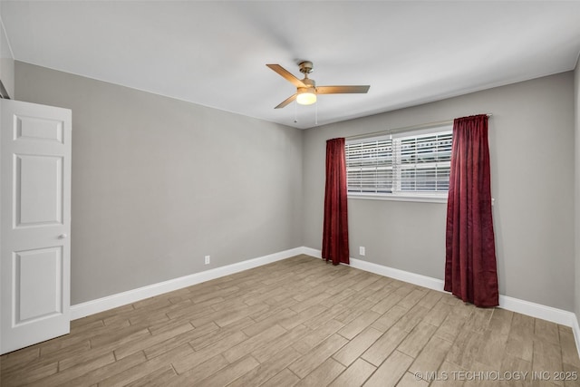 unfurnished room with ceiling fan, wood finished floors, and baseboards