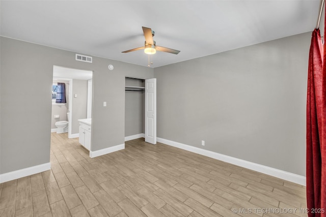 unfurnished bedroom with a closet, light wood-type flooring, visible vents, and baseboards