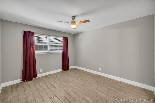 spare room with light wood finished floors, ceiling fan, and baseboards