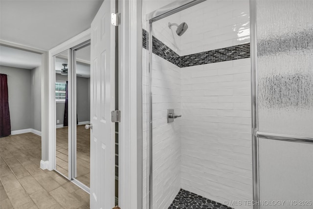 full bath featuring a stall shower and baseboards