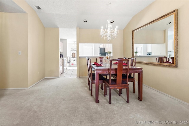 dining space featuring light carpet, baseboards, visible vents, an inviting chandelier, and vaulted ceiling