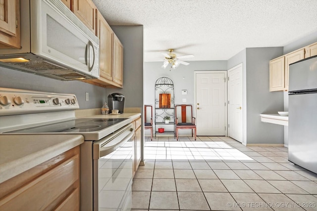 kitchen featuring ceiling fan, white appliances, a textured ceiling, and light tile patterned flooring