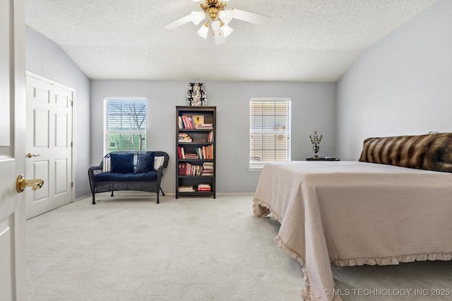 bedroom with light carpet, ceiling fan, and a textured ceiling