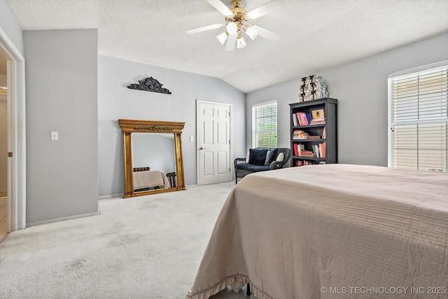 bedroom with carpet, vaulted ceiling, a textured ceiling, and ceiling fan