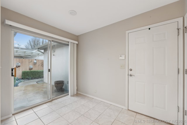 interior space with baseboards and light tile patterned flooring