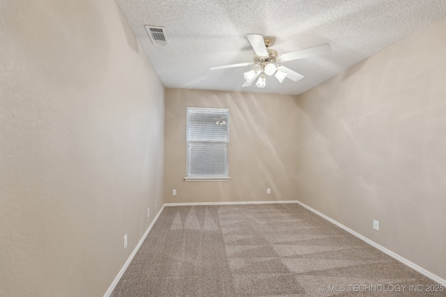 carpeted spare room featuring baseboards, a textured ceiling, visible vents, and a ceiling fan