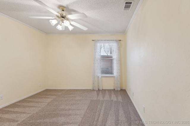 unfurnished room featuring a textured ceiling, ornamental molding, and visible vents