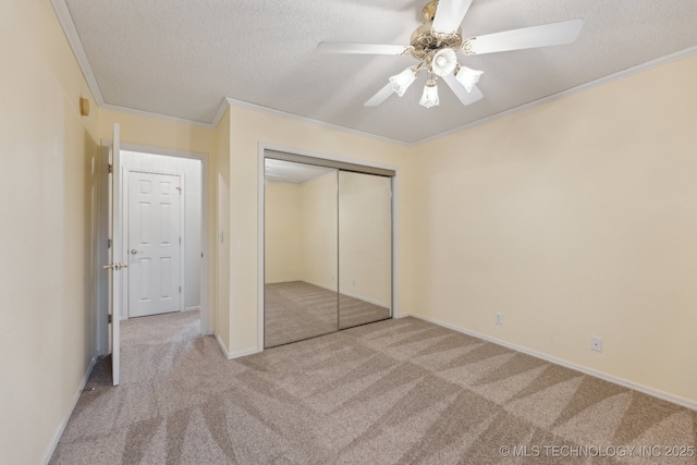 unfurnished bedroom featuring carpet floors, a closet, ornamental molding, and a textured ceiling