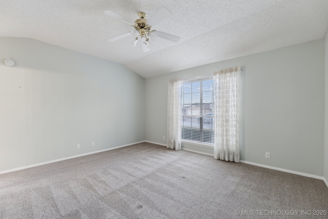 carpeted spare room with a ceiling fan, vaulted ceiling, a textured ceiling, and baseboards