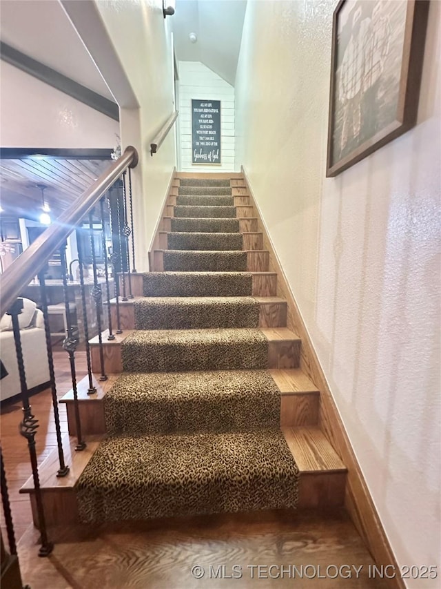 stairway with baseboards and wood finished floors