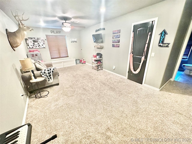 interior space featuring carpet, ceiling fan, and baseboards