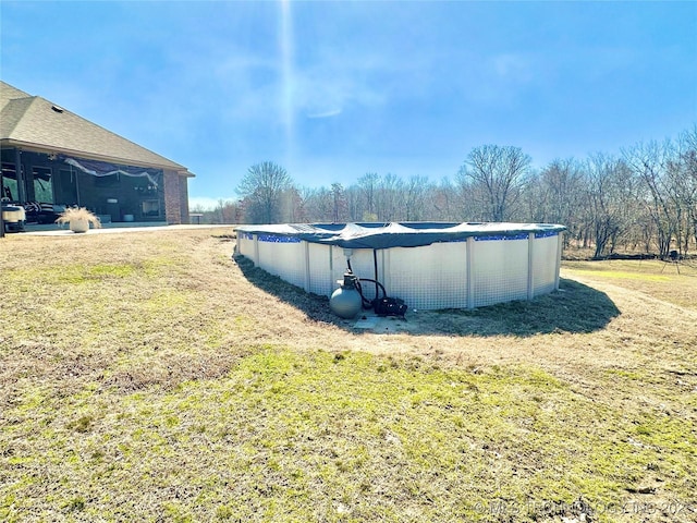 view of side of home featuring a covered pool and a lawn