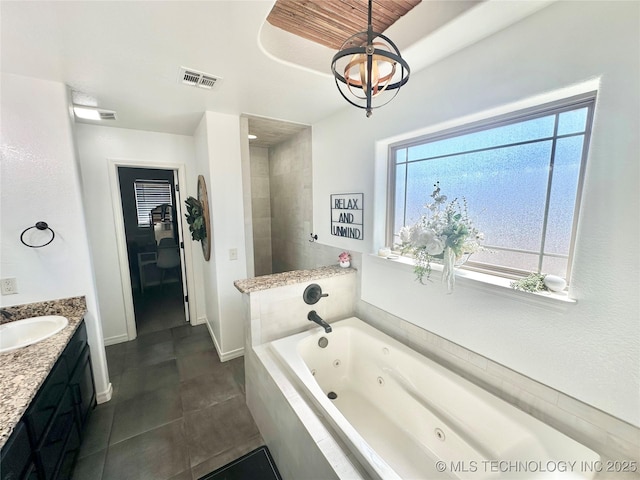 bathroom featuring baseboards, visible vents, a tub with jets, tile patterned flooring, and vanity