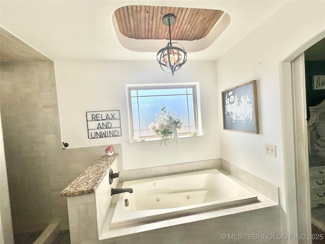 bathroom featuring a whirlpool tub and a chandelier