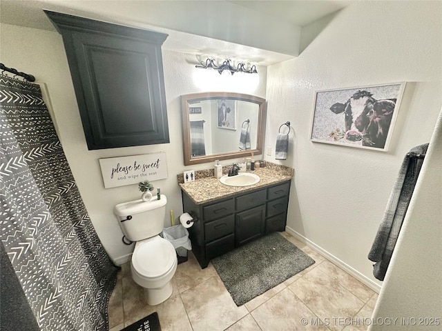 bathroom with baseboards, vanity, toilet, and tile patterned floors