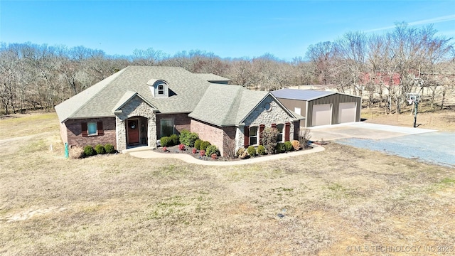 french provincial home with a garage, stone siding, a front lawn, and roof with shingles