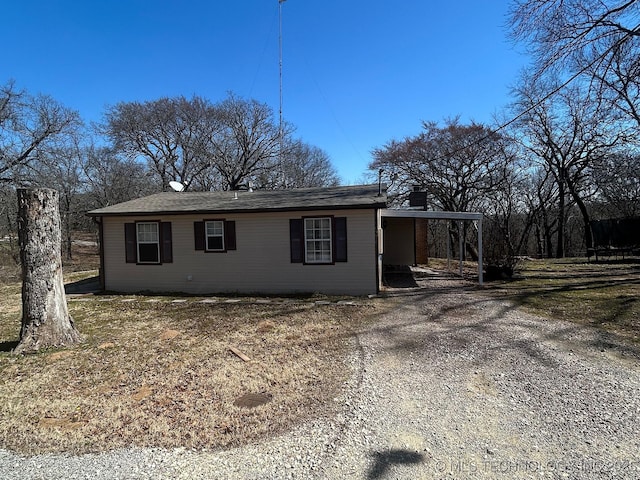 view of side of property with driveway and a chimney