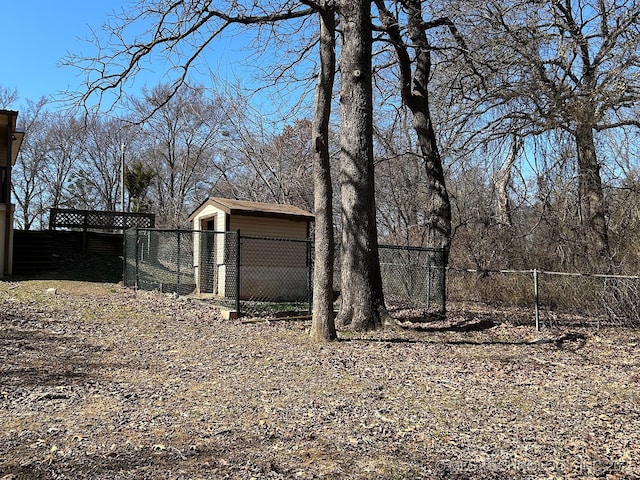 view of yard featuring a storage unit, an outdoor structure, and fence