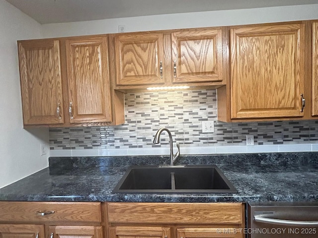 kitchen with brown cabinets, stainless steel dishwasher, a sink, and decorative backsplash