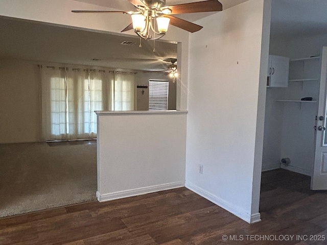 spare room featuring a ceiling fan, wood finished floors, visible vents, and baseboards