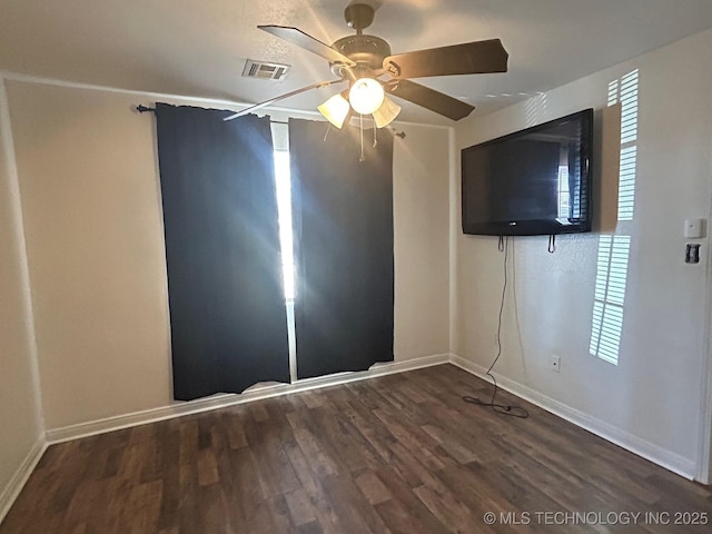 empty room with a ceiling fan, visible vents, baseboards, and wood finished floors