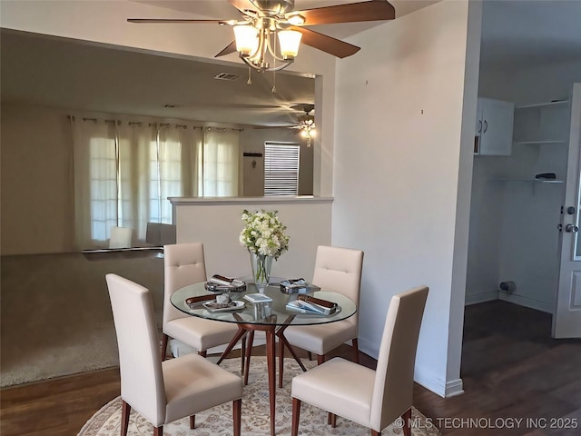 dining area featuring a ceiling fan, visible vents, baseboards, and wood finished floors