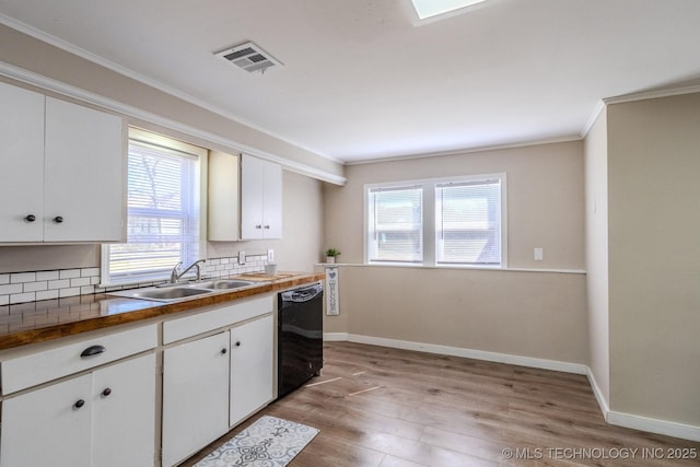 kitchen featuring visible vents, dishwasher, light wood-style flooring, ornamental molding, and a sink