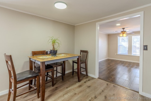 dining space with a ceiling fan, crown molding, baseboards, and wood finished floors