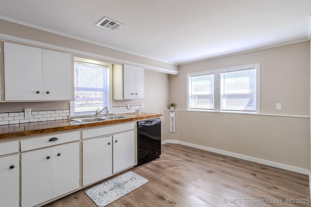 kitchen with light wood-style floors, black dishwasher, visible vents, and a sink