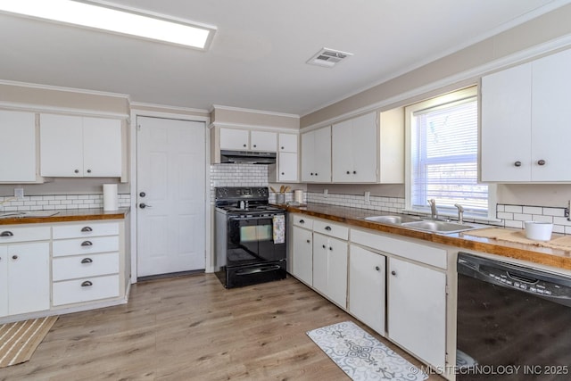 kitchen with under cabinet range hood, a sink, visible vents, black appliances, and crown molding