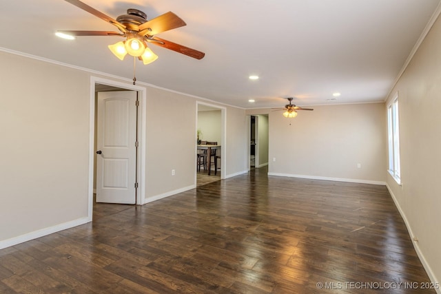 spare room featuring crown molding, dark wood finished floors, and baseboards