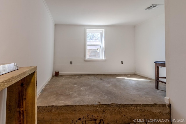 spare room featuring baseboards, crown molding, visible vents, and concrete flooring