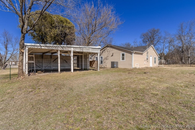 back of property featuring an outbuilding, a pole building, a lawn, and cooling unit