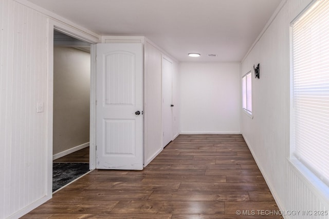 unfurnished room with baseboards and wood finished floors