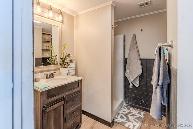 bathroom with visible vents, a walk in shower, crown molding, and vanity